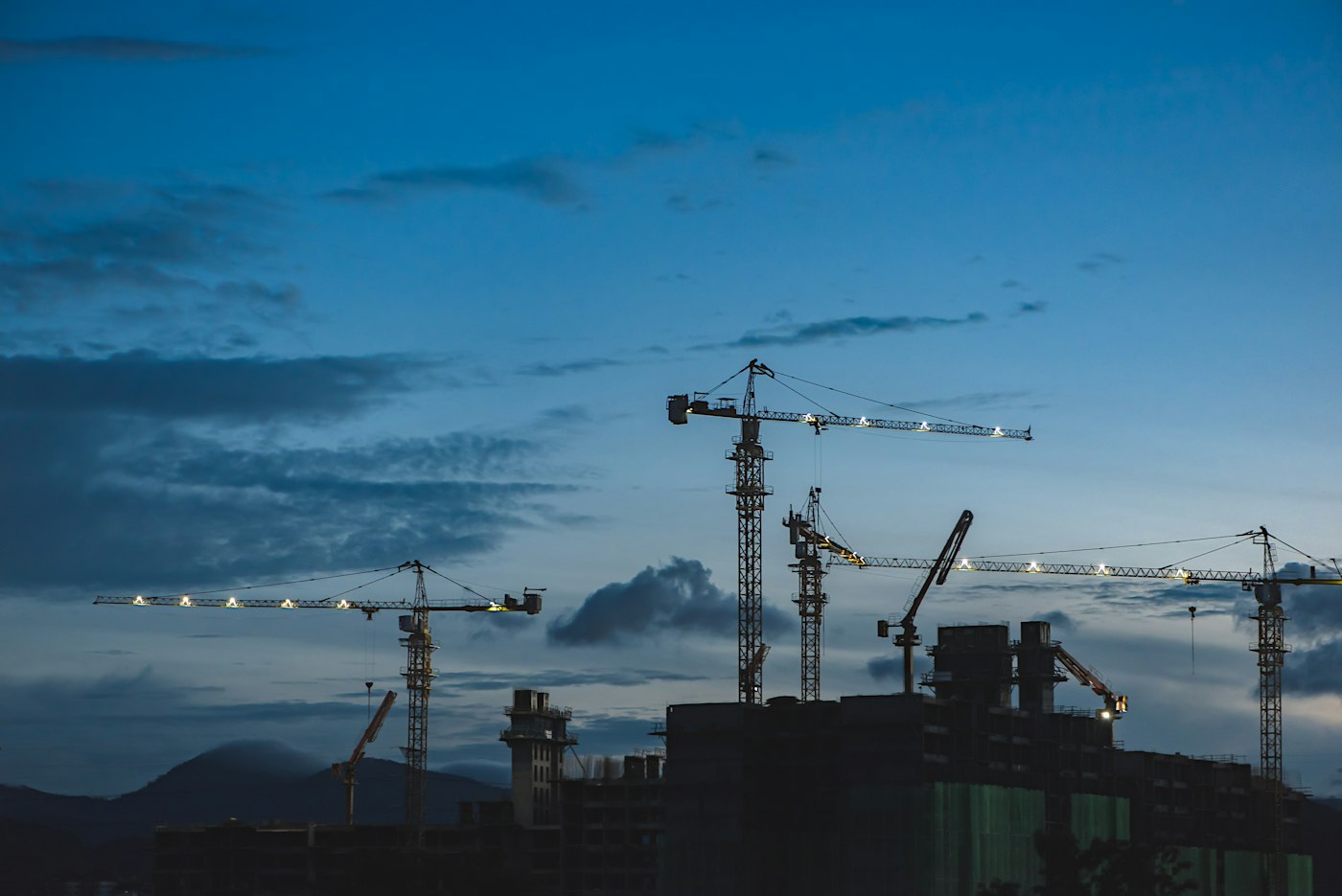 Tower cranes over a developing skyline at dusk