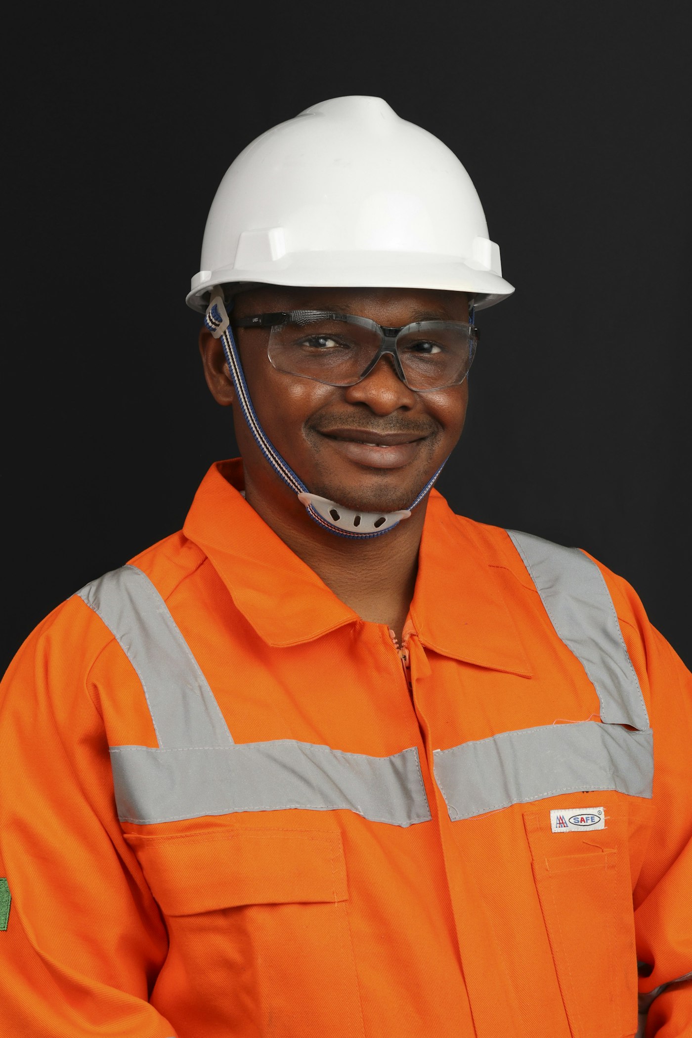 Engineer in a white hard hat and orange high-visibility coverall