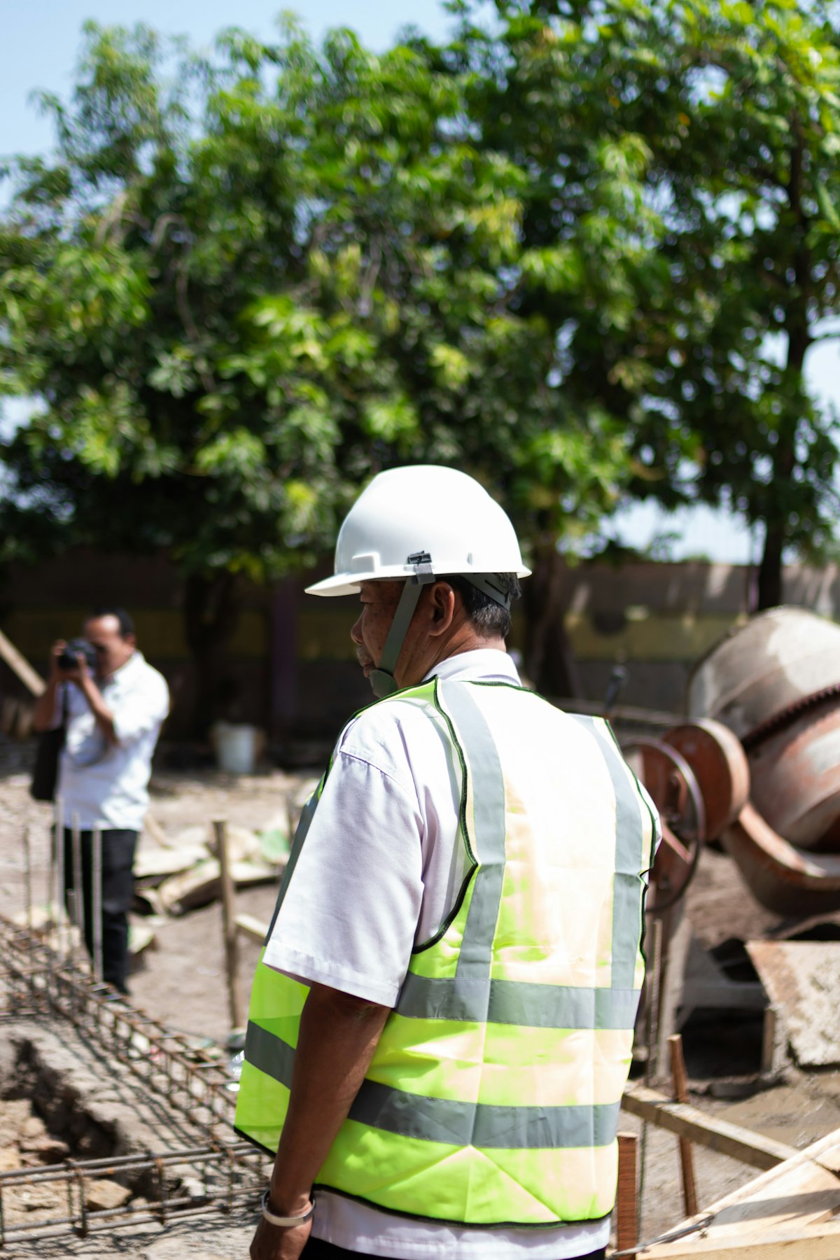 Site inspector in a hard hat and high-visibility vest reviewing works