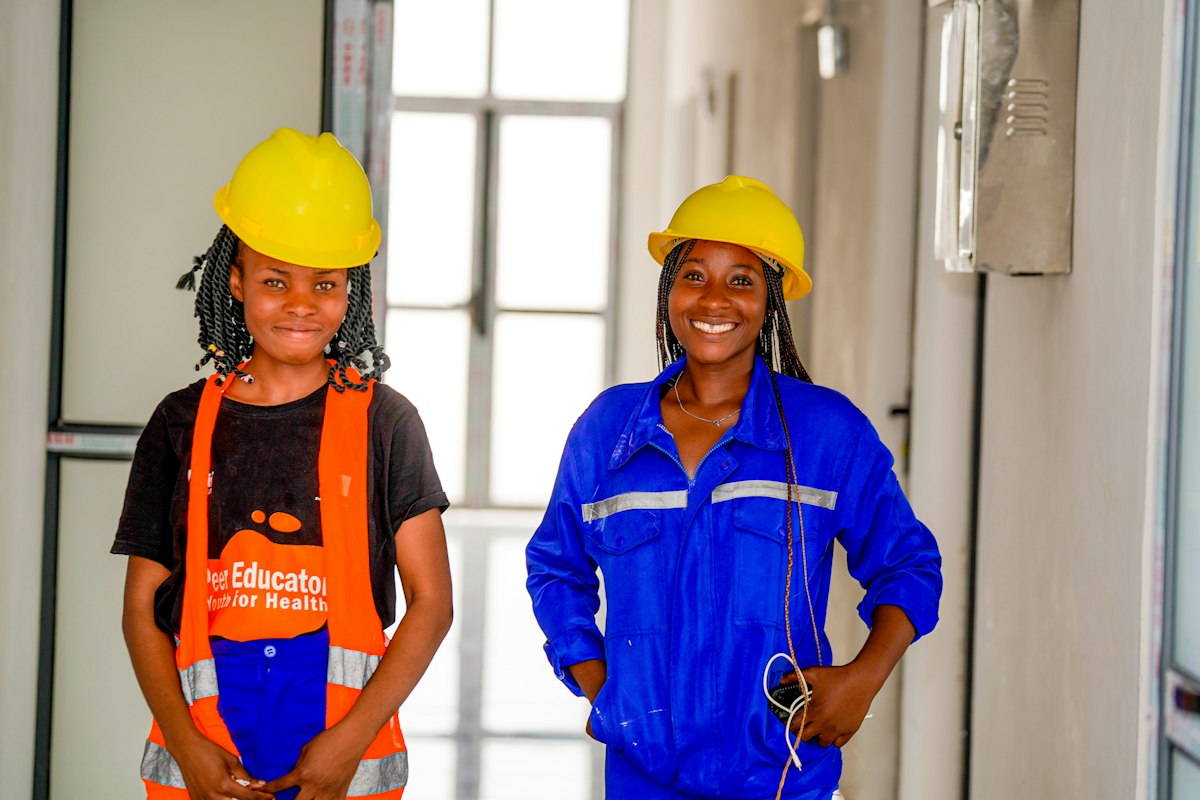 Two engineers in hard hats and workwear smiling on site